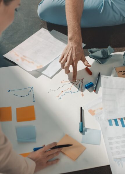 Young business people sitting on floor and working with charts